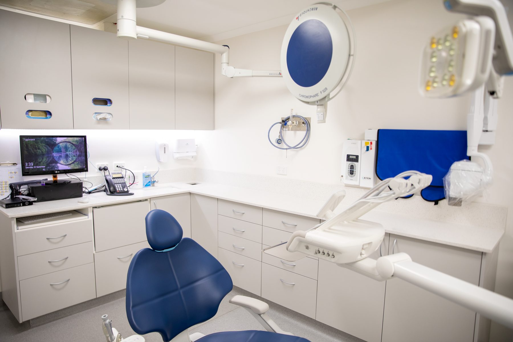 A calm, modern treatment room at Optimal Dental Care, with the dental chair and operating light ready for a patient